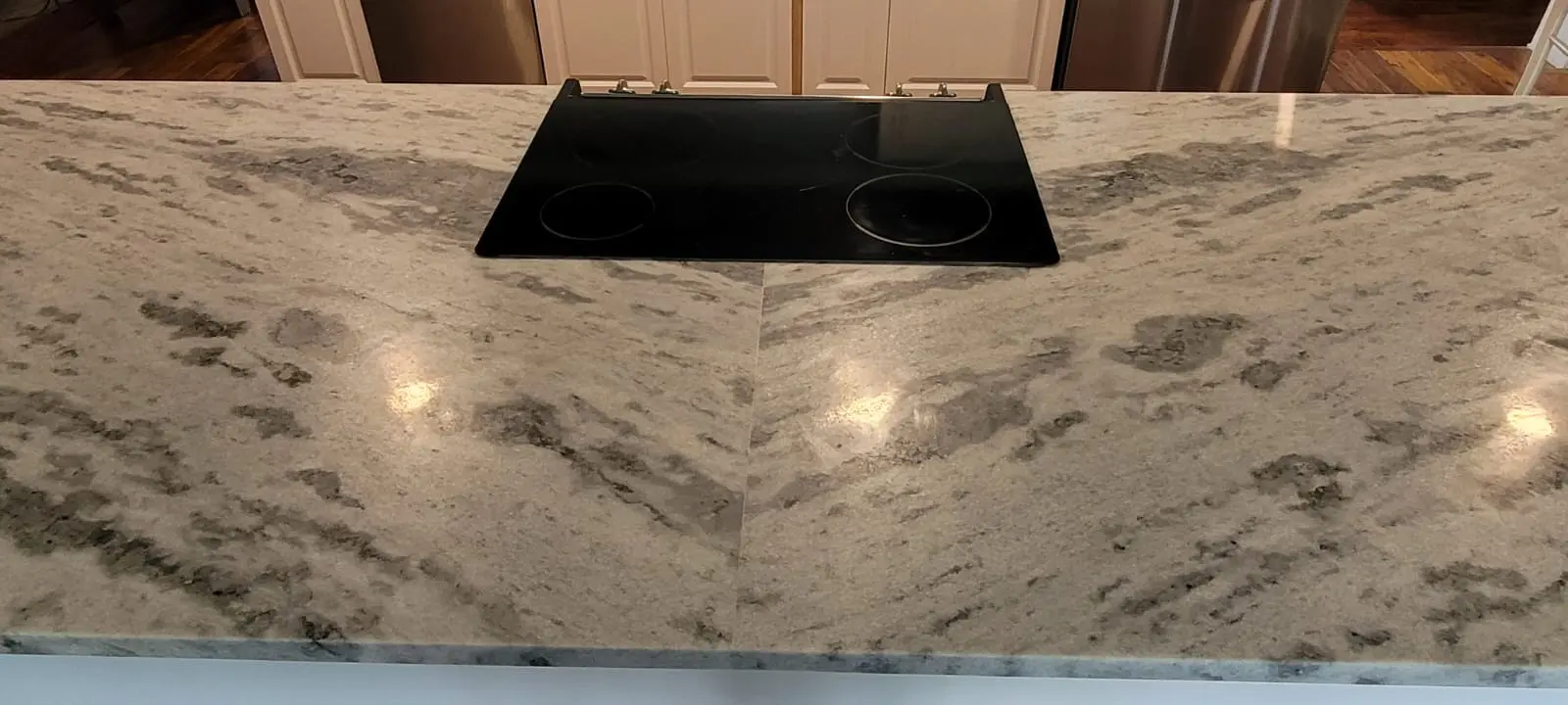 A black stove top sitting on top of a white counter.