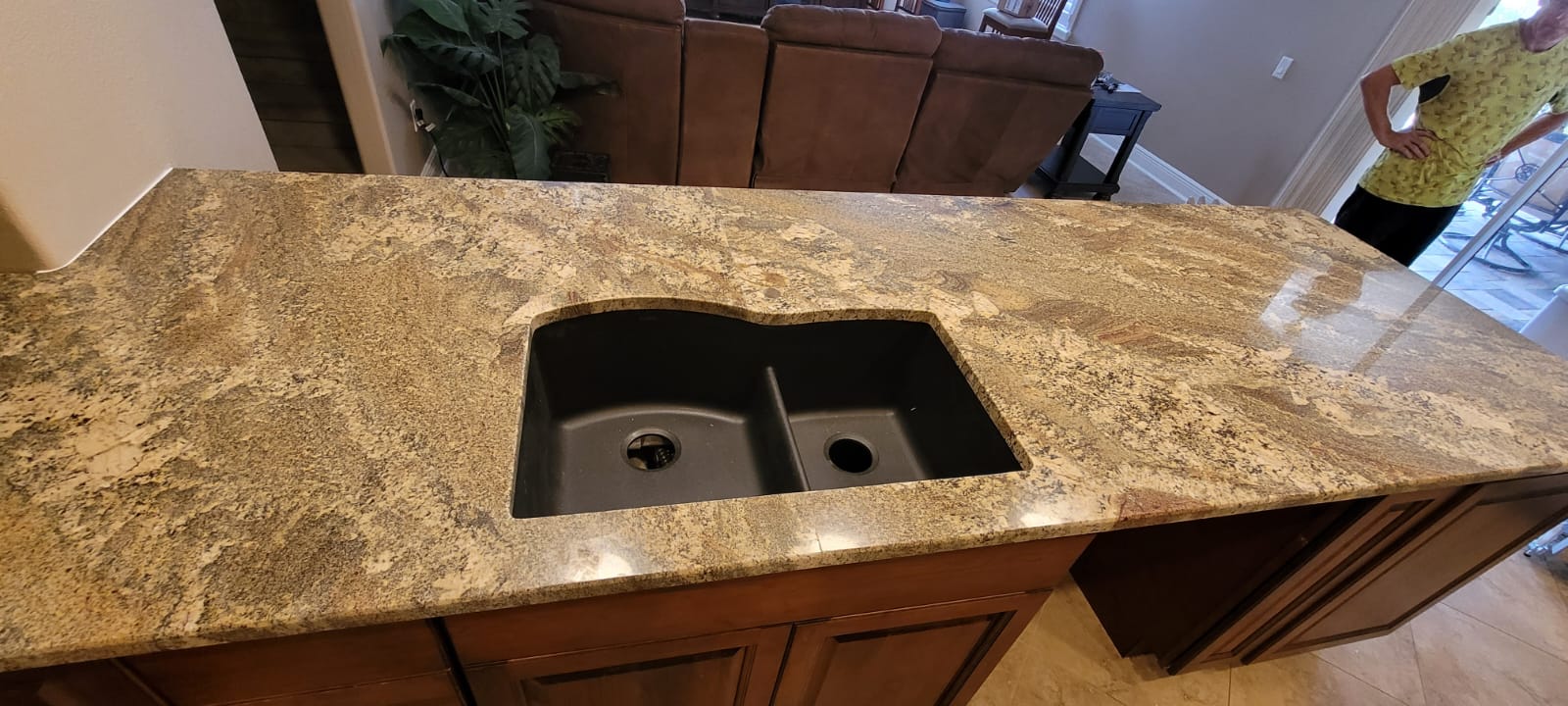 A kitchen counter with two sinks and a wooden cabinet.