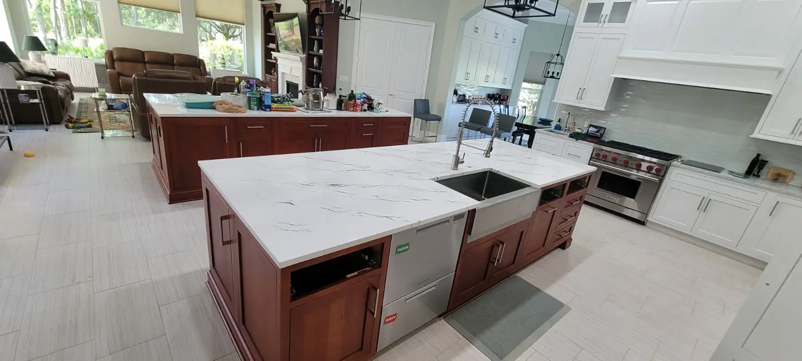 A large kitchen with white counters and wooden cabinets.